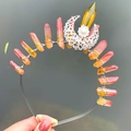 Macro detail of handmade silver headband with orange crystal pillars and moon moon charm - Crown Hairband / Yellow Orange
