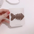 Cute brown matte fishbone hair clip held by hand for a minimalist Korean style - Brown