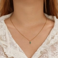 Close-up of a gold necklace featuring a rectangular green zircon pendant on white lace - Necklace / Emerald Green Zirconia Necklace Gold