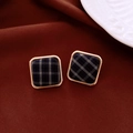 Detail of square gold-framed stud earrings with navy blue plaid fabric inlay on velvet - Dark Blue
