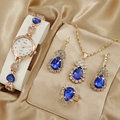 Set orologio e gioielli in oro rosa con gemme blu a goccia su seta beige - Set / Blu Set