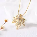 Golden maple leaf pendant necklace with crystals on white background - Maple Leaf / Gold