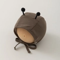 Close-up of brown knit baby bonnet with cute black antenna-like pompoms and ties - 35-45cm 0-12 Months / Brown