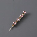Detail shot of a metal hair clip featuring alternating pink and gold marquise crystals - Silver Grey Pink