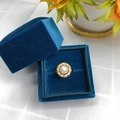 Macro detail of a freshwater pearl ring in a blue velvet box with sunflower decoration - 8-9MM / White