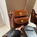 Deep brown vintage crossbody bag with dual golden twist locks and glossy leather finish - Brown