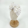 White ribbed baby turban hat with a large gold polka dot tulle bow for infant girls - White