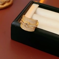 Detailed close-up of a wide gold ring with square cubic zirconia and pave stones - Gold-White Zircon