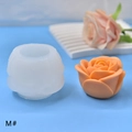 Macro detail van roos siliconen mal en realistische oranje waskaars met bloemblaadjes - M#