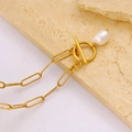 Dettaglio di chiusura a levetta dorata con perla barocca su collana a catena graffetta - Collana