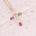 Collana dorata con pendente a croce in zirconi colorati su superficie in pietra - Colorato