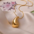 Elegant gold-plated waterdrop pendant necklace displayed on soft silk fabric - Gold