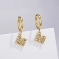 Detail of gold-plated M-letter earrings with sparkling zircon inlay on white stand - Letter M (Style: 0229)