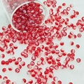 Macro detail of red crackle glass beads spilling from a glass onto soft white fur - 6mm / Red