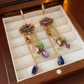Detailansicht goldener Quastenohrringe mit bunten Zirkonias auf einer Schmuckschatulle - Zirkon Wassertropfen Quasten Ohrhaken (24#)