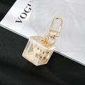 Detail of a clear resin cube keychain with a cute bear and gold foil inside - Yellow Brown Bear
