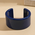 Dettaglio del bracciale rigido in resina blu scuro lucida su trama sabbiosa - Stile Polsino Largo Aperto Blu Scuro