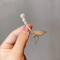 Close-up of elegant gold brooch featuring gradient pearls and sparkling micro-diamonds - Gold Pearl Tassel