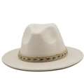 Detail of wool fedora hat with colorful woven band on light beige wide brim felt surface - Beige