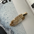 Close-up of marble pattern acetate hair clip with golden metal base on a magazine - No-Crease Hair Clips / Milk Apricot