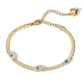 Goldenes Evil-Eye-Schlangenkettenarmband mit Herzanhänger auf minimalistischem Grund - Gold