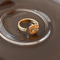 Detailed macro of gold plated ring with cubic zirconia and stylish buckle design - Open Belt Buckle Style / Gold