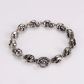 Close-up of silver punk skull link bracelet with detailed 3D gothic metallic skulls - Steel