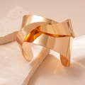 Nahaufnahme des polierten Goldknoten-Armreifs mit glatter Oberfläche auf Steingrund - Einheitsgröße (Verstellbar) / Gold