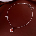 Detail einer silbernen Halskette mit rotem Herzanhänger und Hand-Charm auf Seide - Herzanhänger Stil / Silber-Rot