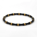 Détail macro d'un bracelet en acier titane en forme de bambou avec émail noir et plaqué or - Noir