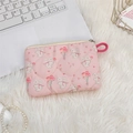 Flat lay of quilted pink rabbit pouch with floral prints on a white plush background - Bouquet Rabbit