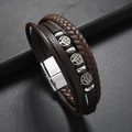 Detail van levensboom-bedels aan een meerlaagse bruine gevlochten leren armband met magneetsluiting - Bruin