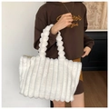 Close-up of white plush striped tote bag worn by model over a dark brown sweater - Off White