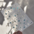 Primer plano de pegatinas para uñas con estrellas, lunas y corazones en oro y azul brillante - to4425-Luna Estrella Corazón-Circonio Azul