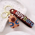 Porte-clés Capybara mignon avec sangle bleue et bande en silicone marron gravée - Sac à Dos Bleu