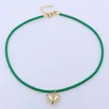 Close-up of green woven cord choker featuring a gold heart pendant and lobster clasp - Green