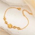 Close-up of a gold floral bracelet with sparkling zircon accents on stone surface - White Zircon Flower Style