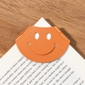 Orange leather corner bookmark with smiling face design and white stitching detail - Orange