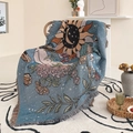 Detail of bohemian sun and moon woven blanket with tassel edges on a rattan chair - 130x160cm / Retro Blue Bohemian Goddess