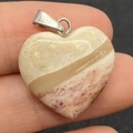 Handheld view of heart-shaped natural stone pendant with spotted beige and purple textures - 20mm / Size 17