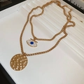 Dettaglio di collana a doppio strato dorata con pendente occhio e disco in metallo martellato - Set da 2 Pezzi Collana con Occhio del Diavolo e Moneta Rotonda