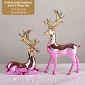 Set di statuette a forma di cervo sfumato rosa e oro, in resina, altezze 32 cm e 22 cm - Set da 2 Pezzi (In Piedi e Seduto) / Sfumatura Oro Rosa Galvanizzato