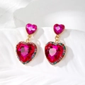 Dettaglio di orecchini a cuore con cristalli colorati e pietra magenta su oro - Cuore Rosa Forte