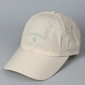Detail van groen klavertje borduursel op de gebroken witte sneldrogende honkbalpet voor sport - Beige