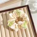 Beige satin floral scrunchie with green ribbon bows on a jewelry display tray - White Band Green Bow