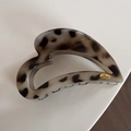 Close-up of tortoise shell heart hair claw clip with golden Love logo engraved on label - Heart-Shaped / Light Tortoiseshell