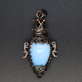 Close-up of vintage bronze crown pendant with drop-shaped opal and star engraving - Opal