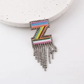 Macro shot of colorful embroidered Z-shaped brooch with shimmering rhinestone tassels - Letter Z