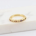 Detailopname van gouden verstelbare ring met gekleurde zirkonia op wit marmer - Minimalistische Ruitvormige Gekleurde Zirkoon