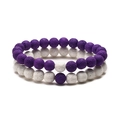 Detail of purple and white lava stone beaded bracelets showing porous mineral texture - Purple